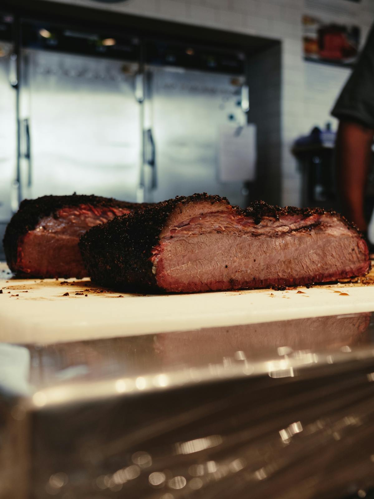 Sliced smoked brisket on a cutting board, the kind of leftover slices that need a careful reheat to stay juicy